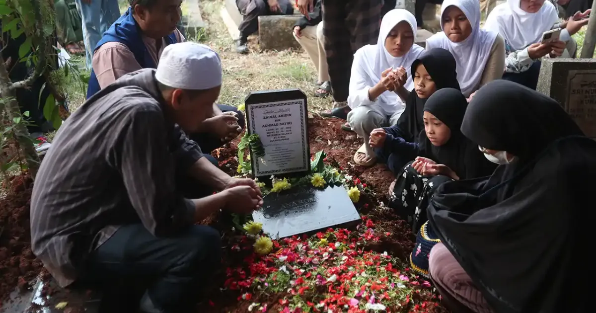 Keluarga memanjatkan doa di depan pusara makam Diding Boneng