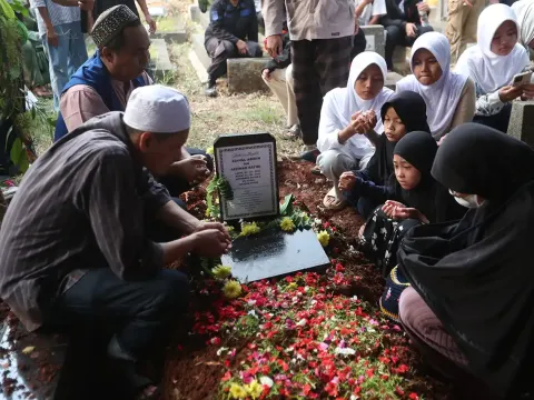 Keluarga memanjatkan doa di depan pusara makam Diding Boneng